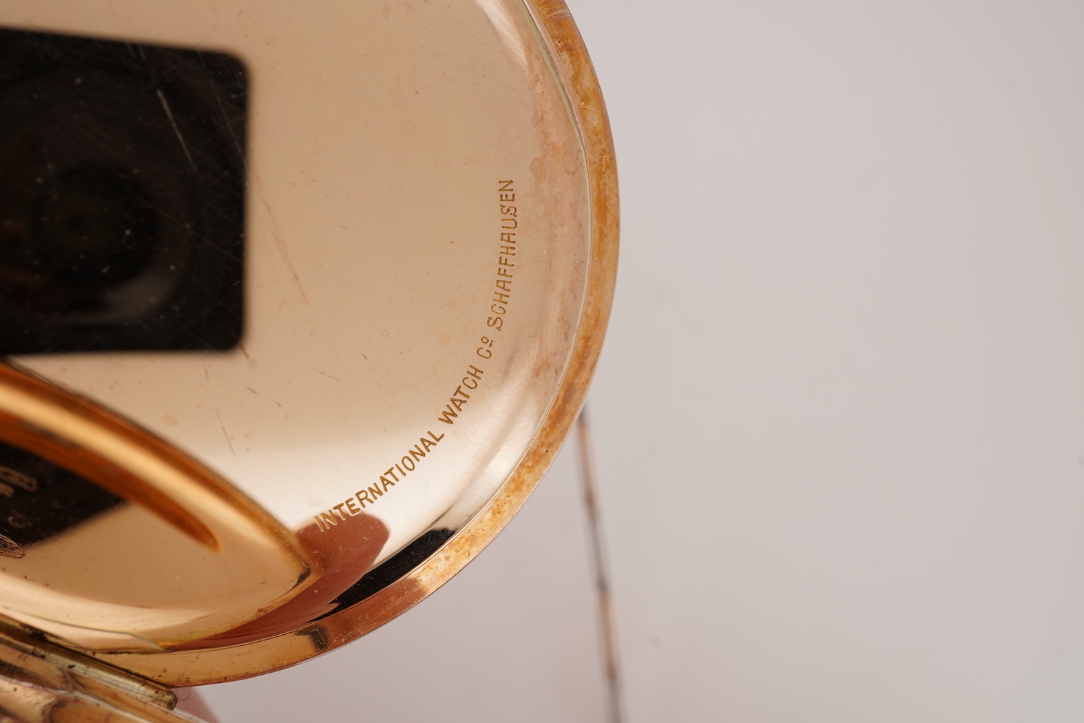 An early 20th century International Watch Company engine turned 14k yellow metal open faced keyless lever pocket watch, together with a Viennese? two colour yellow metal albert, maker's mark, LE